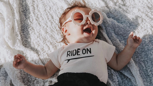 baby wearing cute baby bodysuit and sunglasses