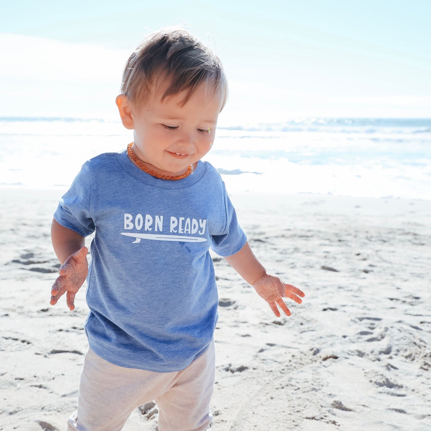 Boy wearing sky blue Born Ready T-Shirt on the beach