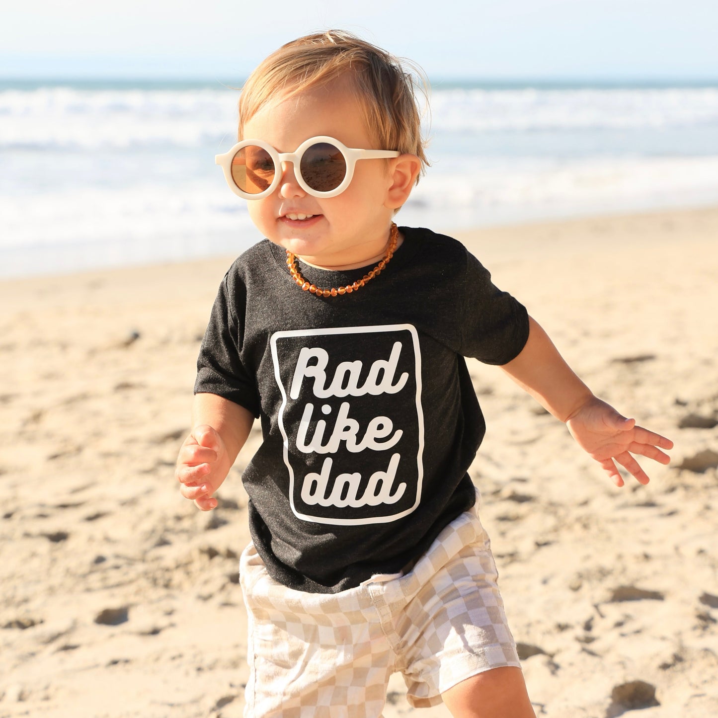 Little boy wearing the Rad Like Dad T-Shirt on the beach